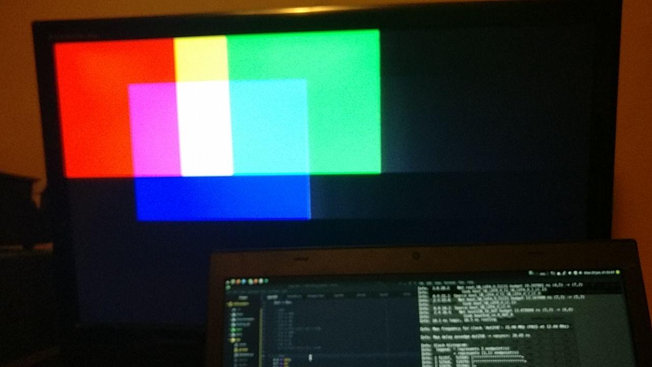 A monitor with blocks of green, red, and blue overlapping to show different colors, with a lot of ghosting due to noise